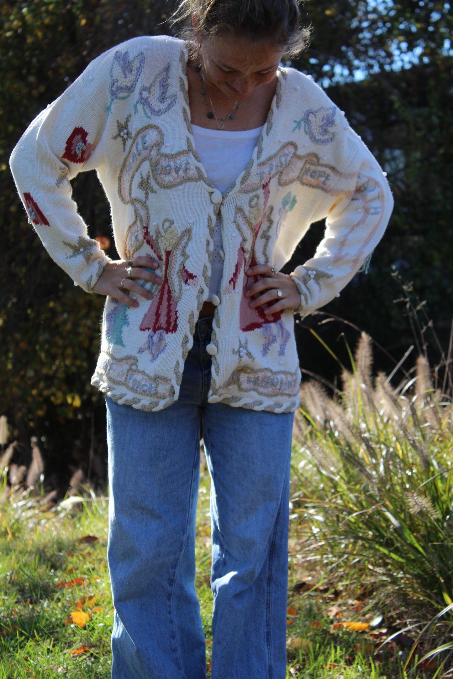 White button-up sweater featuring embroidered angel designs and delicate beaded details on the front.”