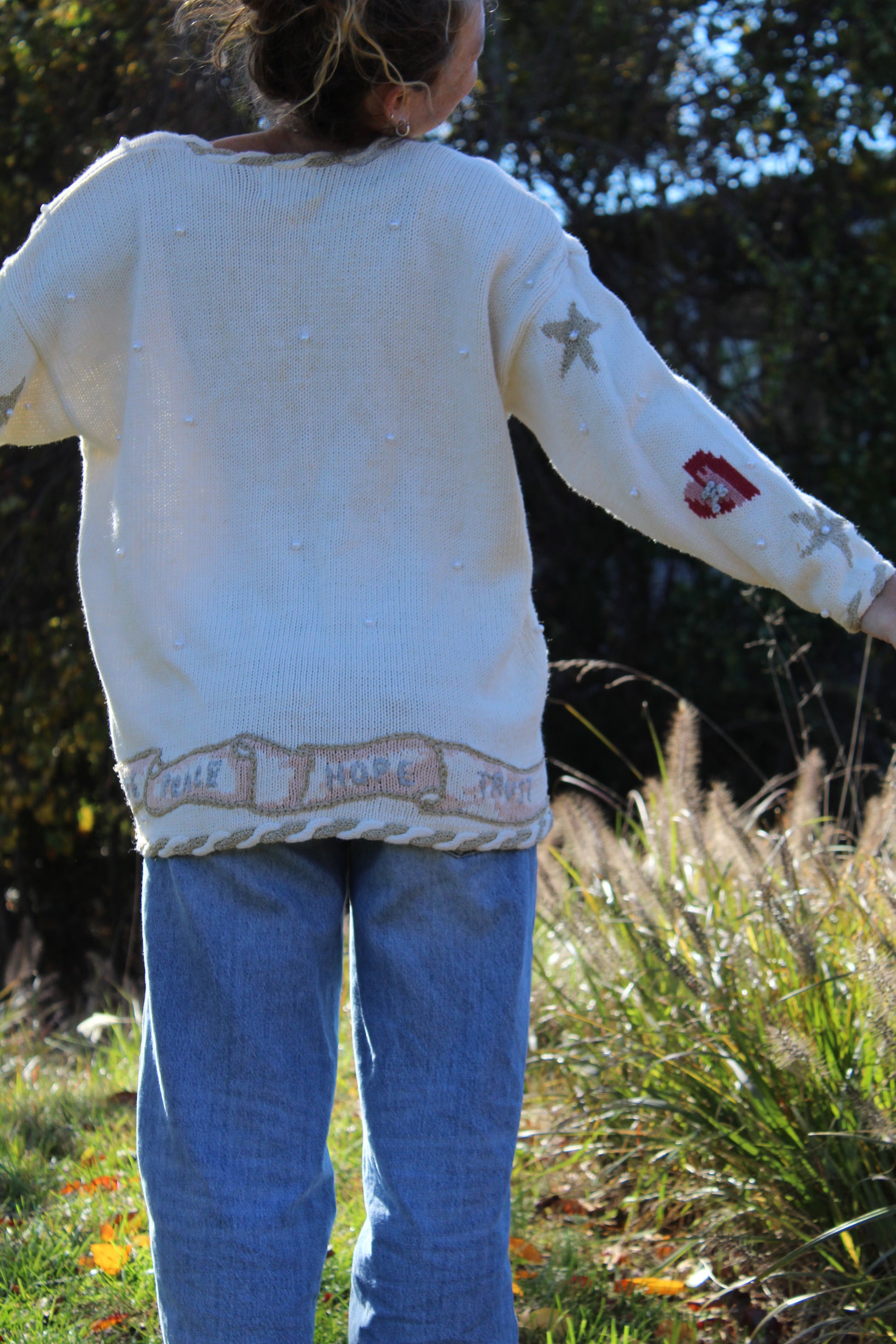 “Front view of a white button-up cardigan decorated with detailed angel artwork and textured embroidery.”