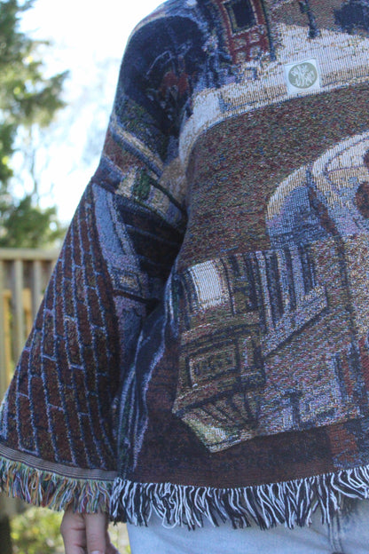 Colorful vintage blanket hoodie with bohemian fringe and ornate woven textures.