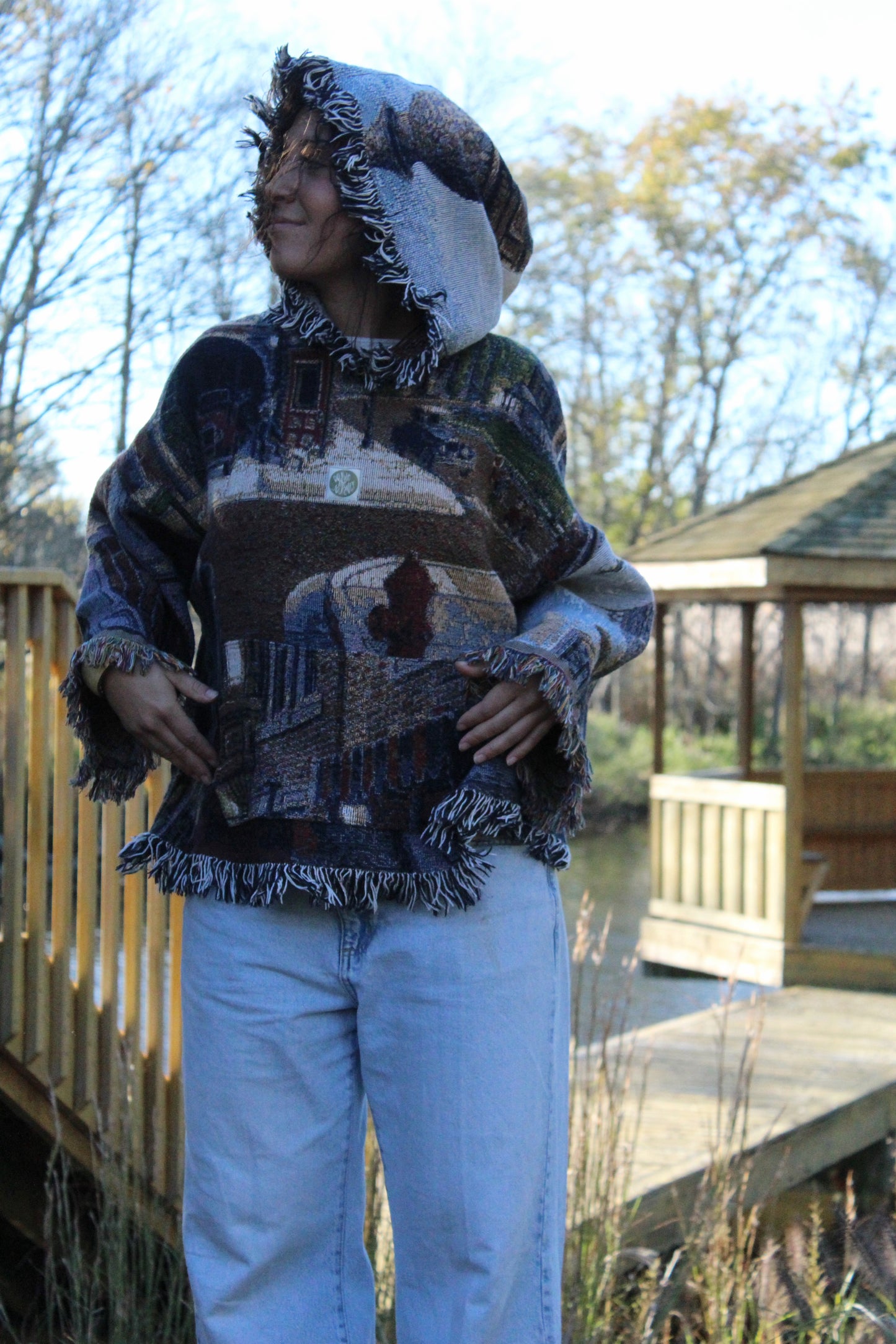 Upcycled blanket hoodie with fringe and striking vintage-inspired woven details.