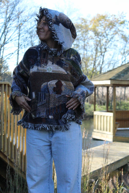 Upcycled blanket hoodie with fringe and striking vintage-inspired woven details.