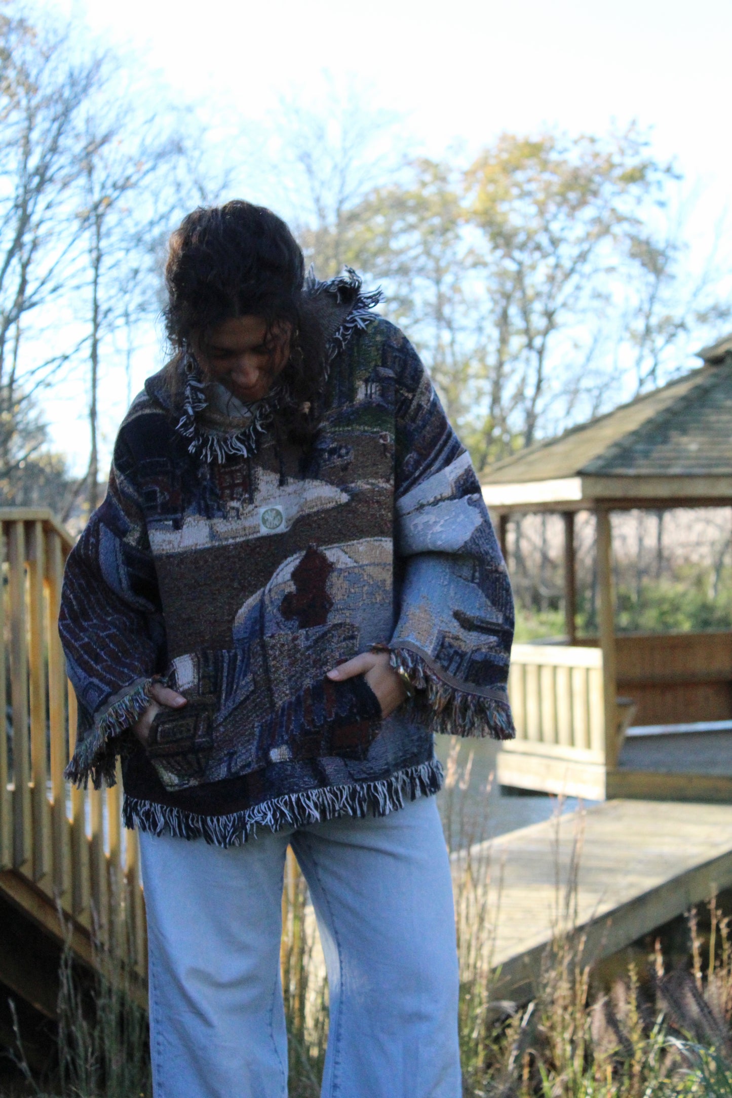 Cozy vintage-style hoodie made from a patterned blanket, finished with fringe edges.