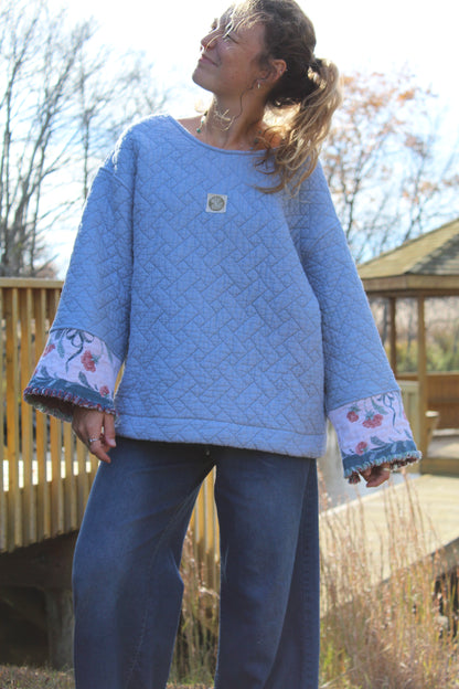 Handmade blue crewneck made from repurposed quilt, styled with unique floral fringe sleeves.