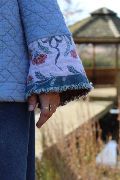 Blue patchwork crewneck made from vintage quilt, featuring soft texture and fringe-trimmed sleeves