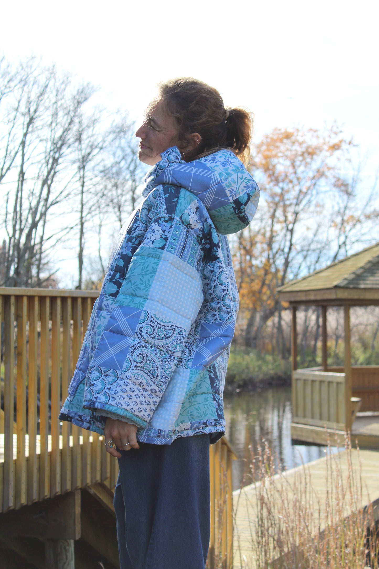 Model wearing blue quilted hoodie with patchwork design and cozy vintage texture