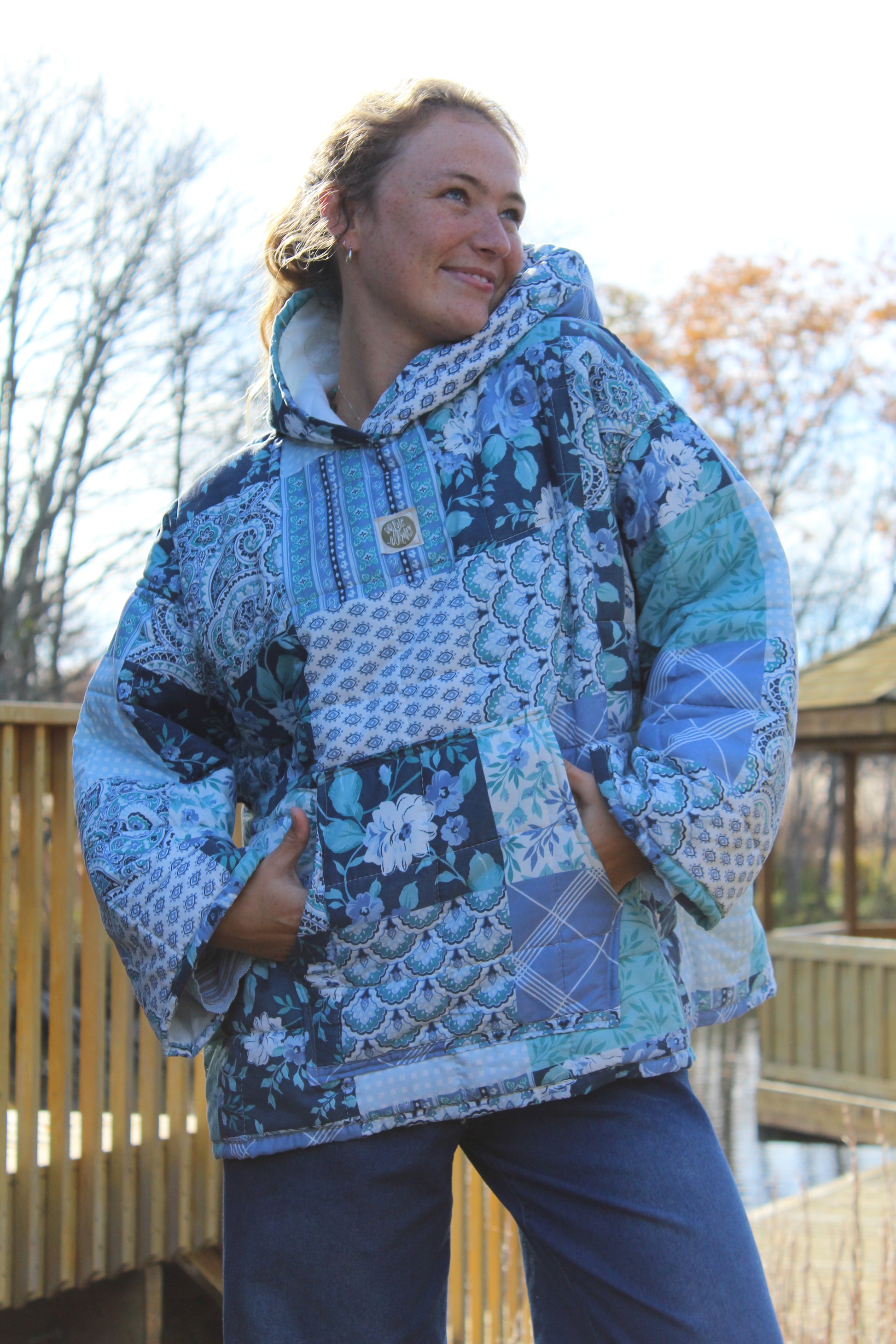 Close-up of handmade blue quilt hoodie showing intricate quilt stitching and soft cotton fabric.