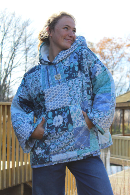 Close-up of handmade blue quilt hoodie showing intricate quilt stitching and soft cotton fabric.