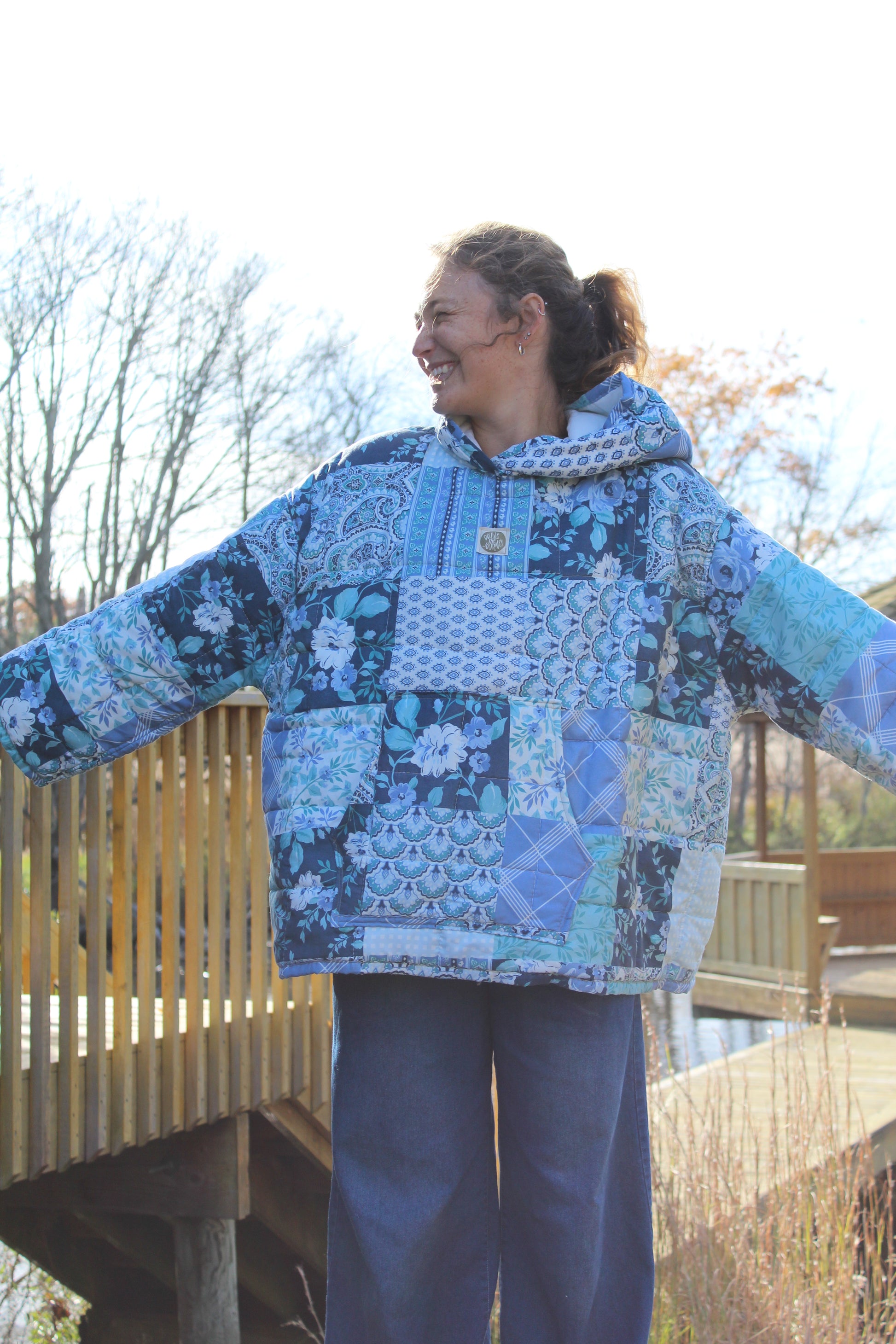 One-of-a-kind blue patterned hoodie made from repurposed vintage quilt, laid flat.