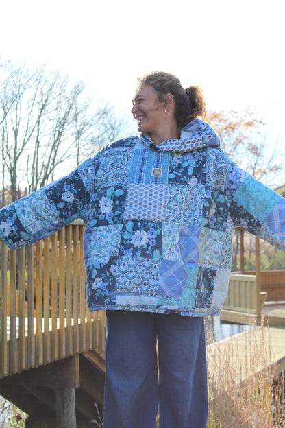 One-of-a-kind blue patterned hoodie made from repurposed vintage quilt, laid flat.