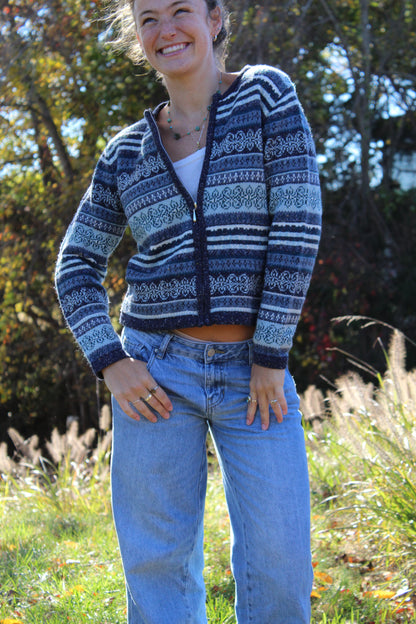 Close-up of a blue patterned zip-up showing detailed knitwork.