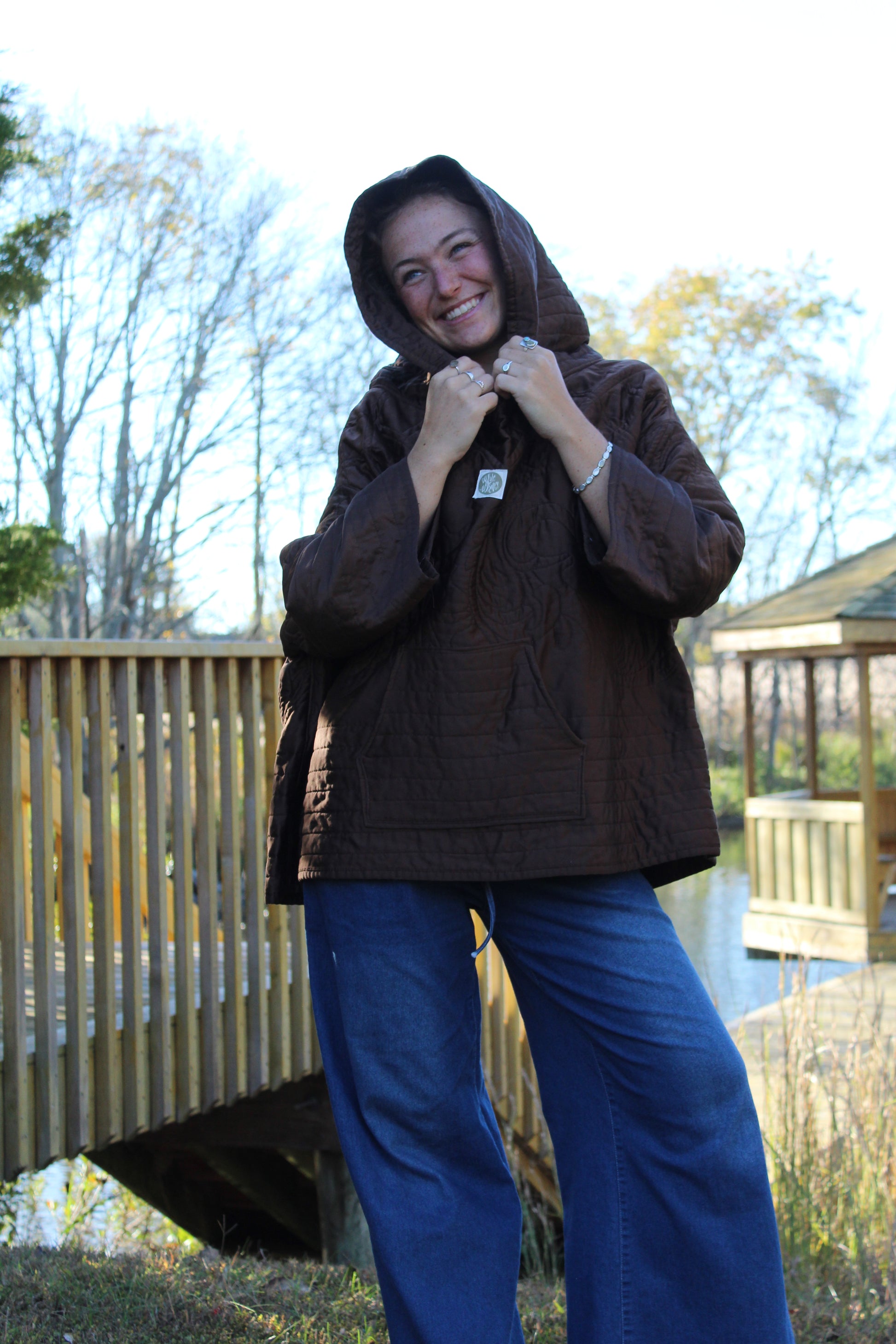 Cozy brown quilted hoodie with shiny embroidered flower details, giving a handmade touch.