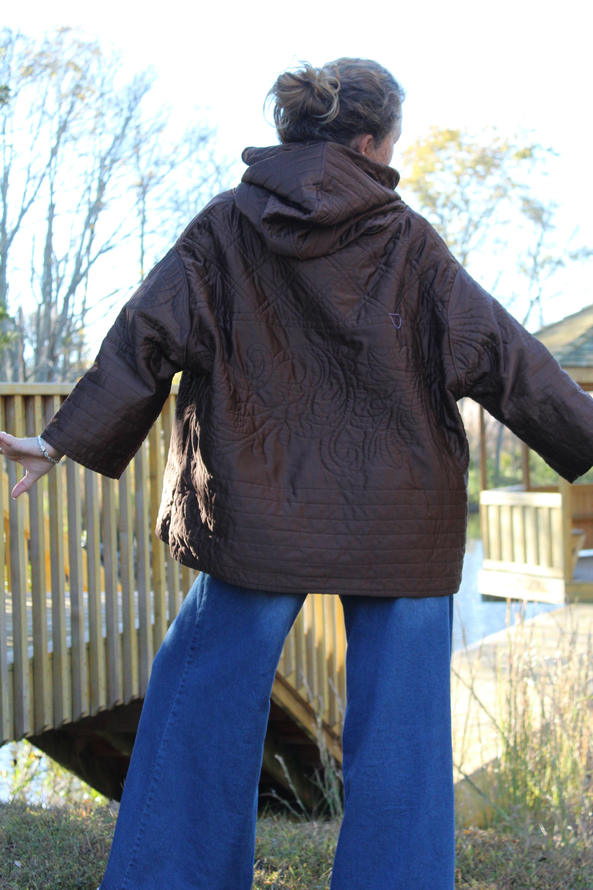 Brown quilted sweatshirt with silky floral stitching, blending comfort and charm.