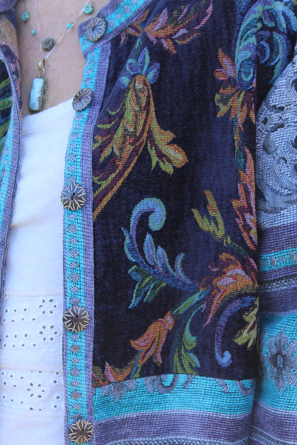 Vintage-inspired blue burlap jacket decorated with floral designs and character-filled buttons.