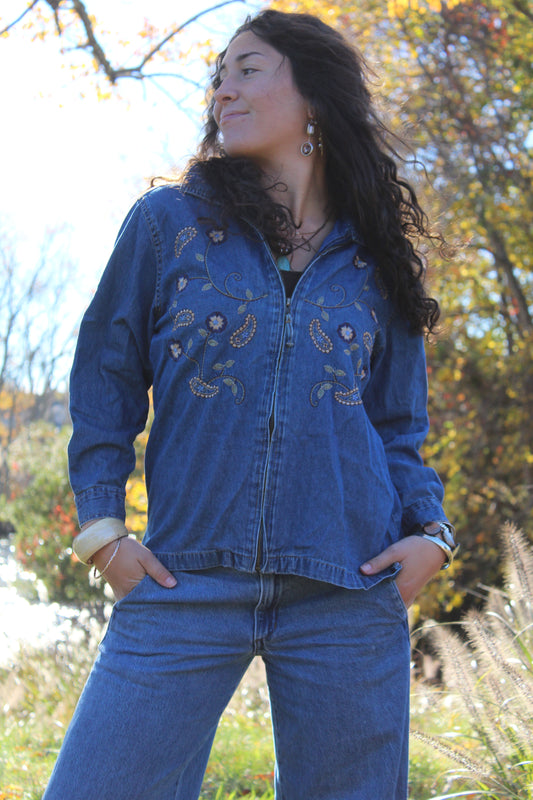 Lightweight medium-wash denim jacket with embroidered details and a front zipper.