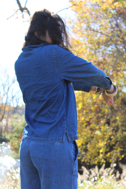 Close-up of a lightweight denim zip-up showing embroidered detailing.