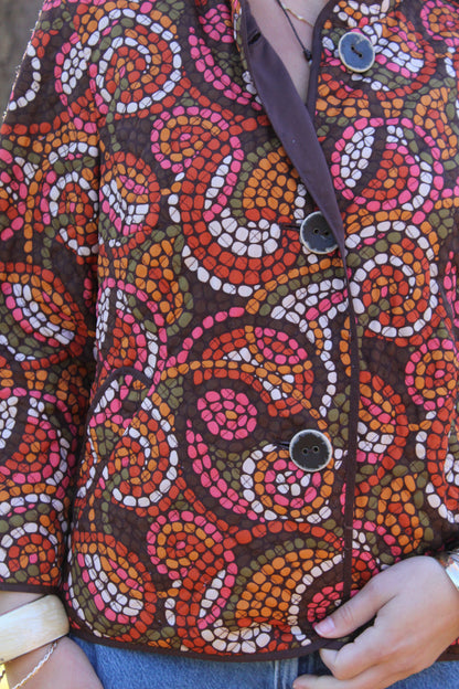Thin quilt material jacket with a playful red and orange polka dot design and button closures.