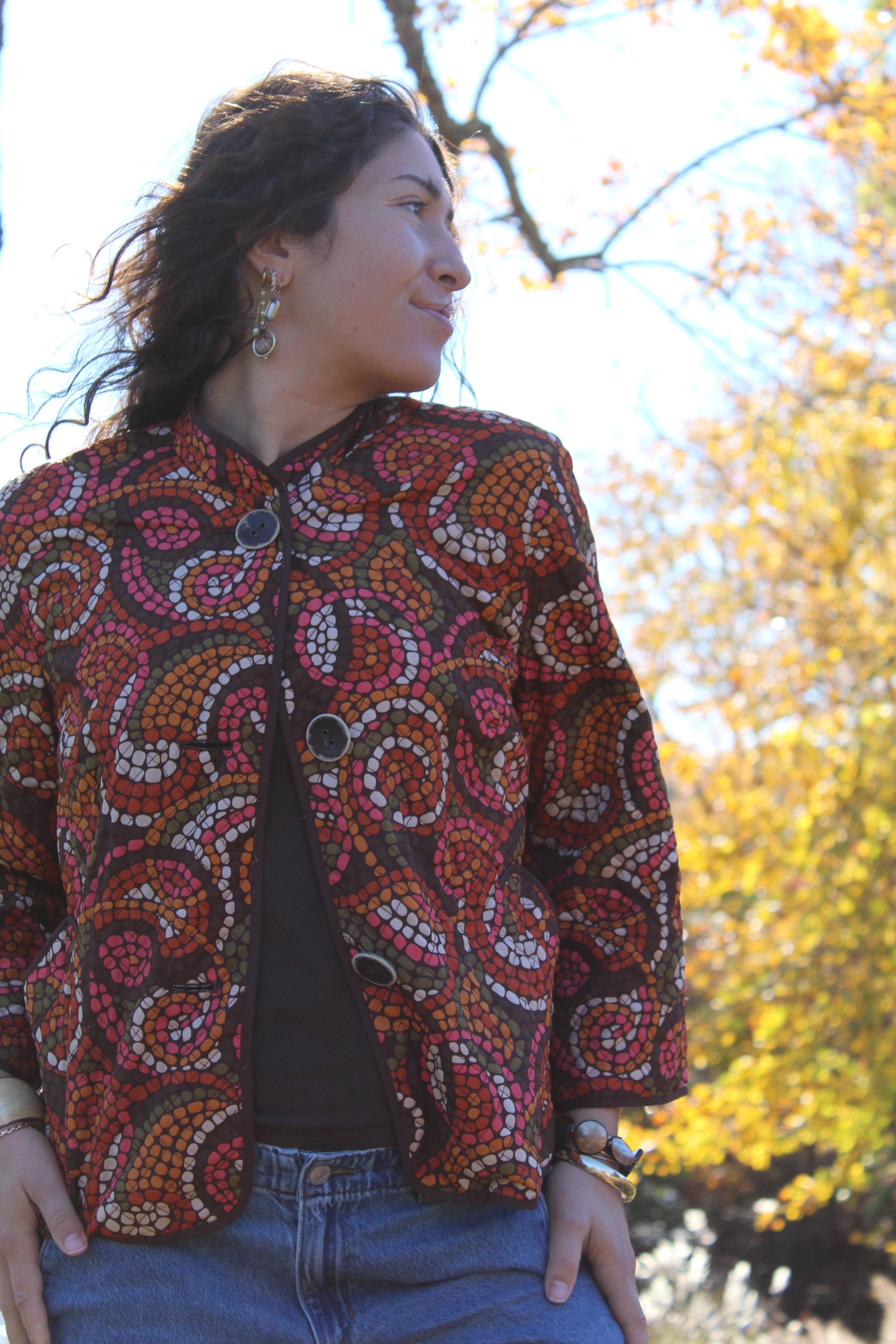 Vintage-inspired thin quilt top with orange and red dot patterns and buttons down the front.