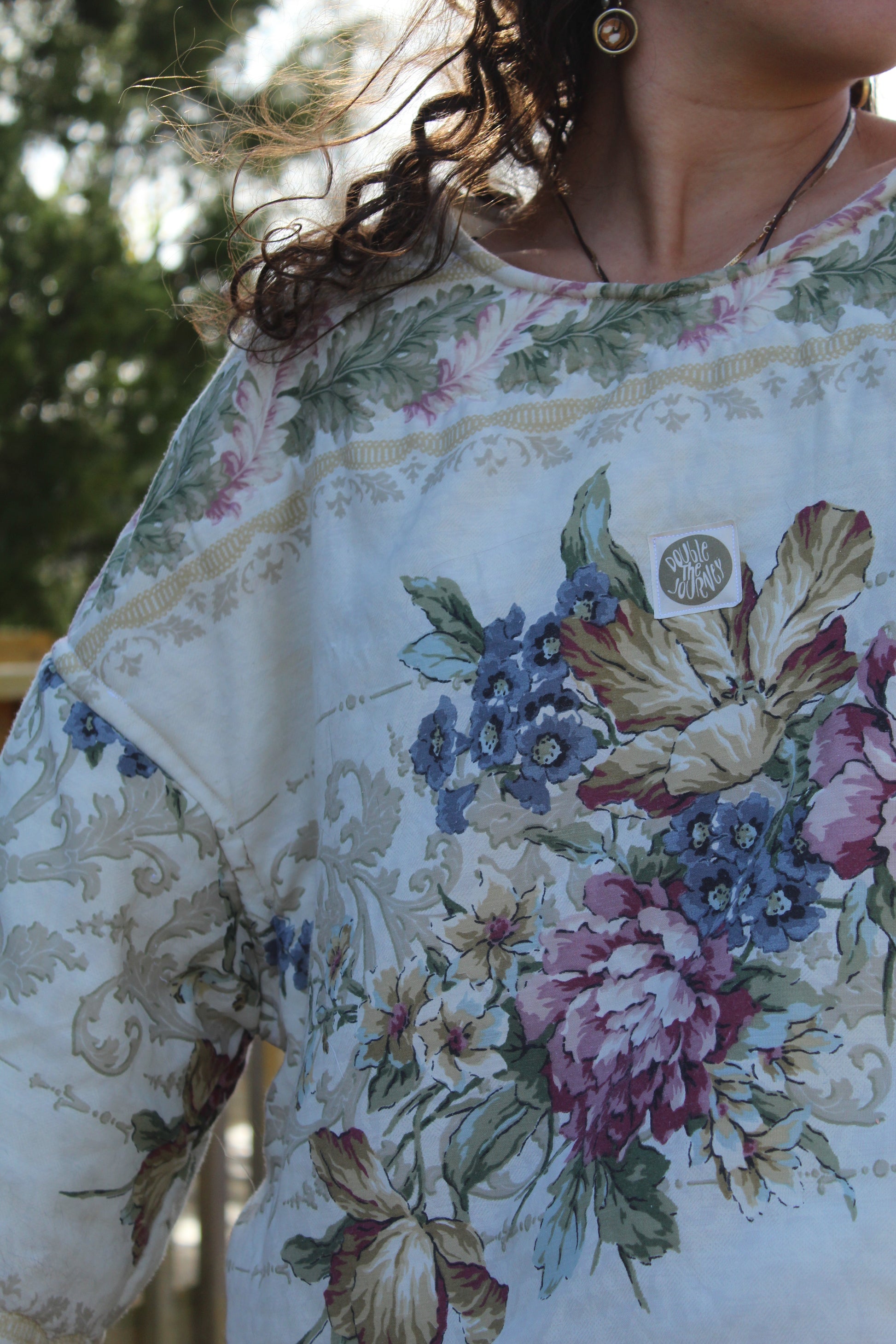 Close-up of floral patchwork detail on handmade crewneck made from vintage bedding
