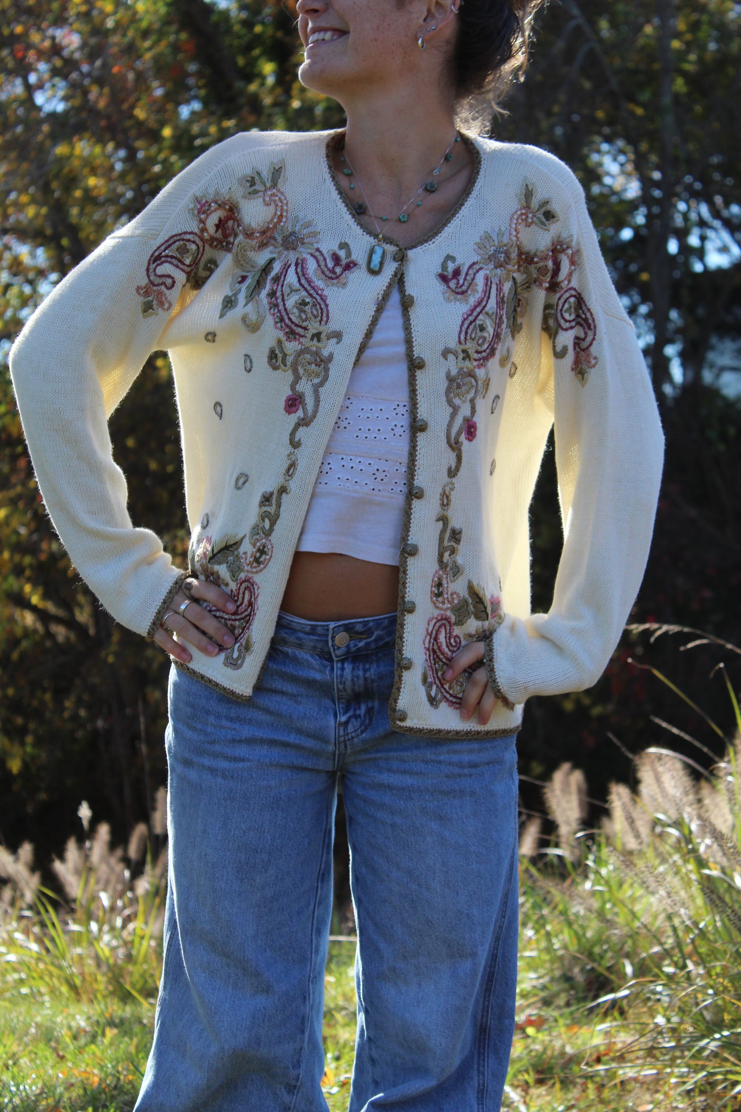 Vintage-inspired sweater with embroidered flowers, gold trim, and front buttons.