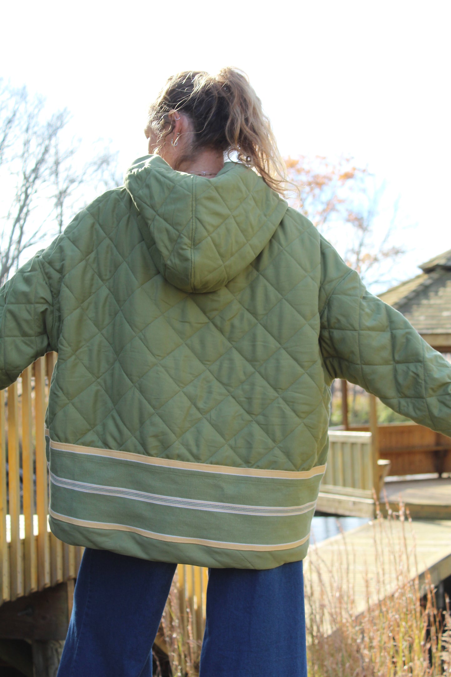 “Men’s large green hoodie made from repurposed fabric with yellow stripe detail.”