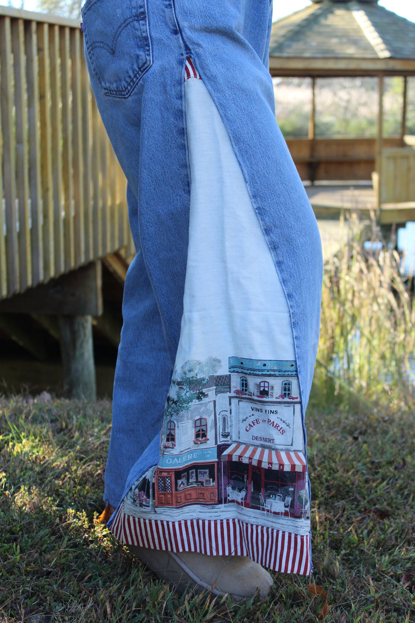 Customized vintage Levi’s featuring tapestry-style side panels with a European scenic print.