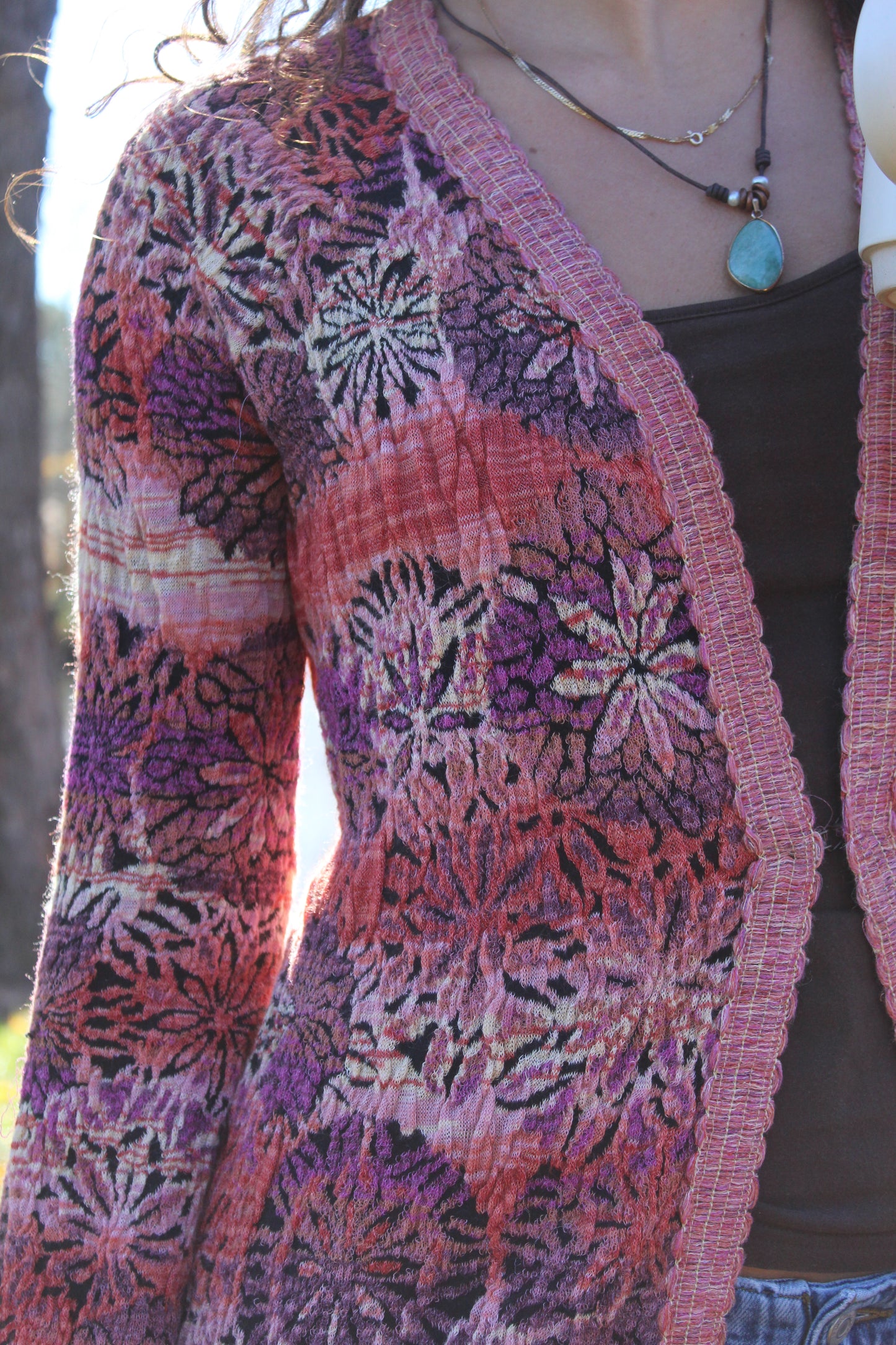 Cozy long floral sweater in red and purple with playful fringe and secure front clasp.