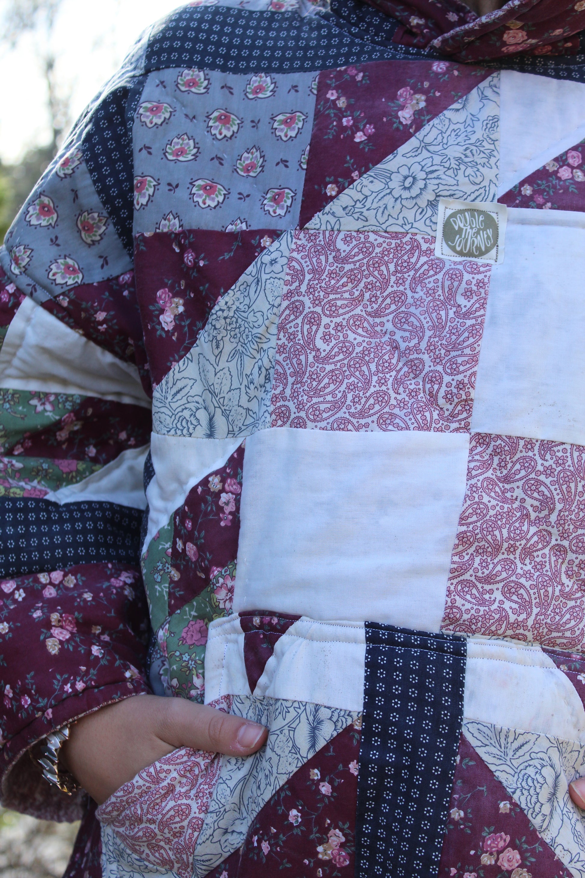 One-of-a-kind quilted hoodie with dark red and blue vintage fabric squares.