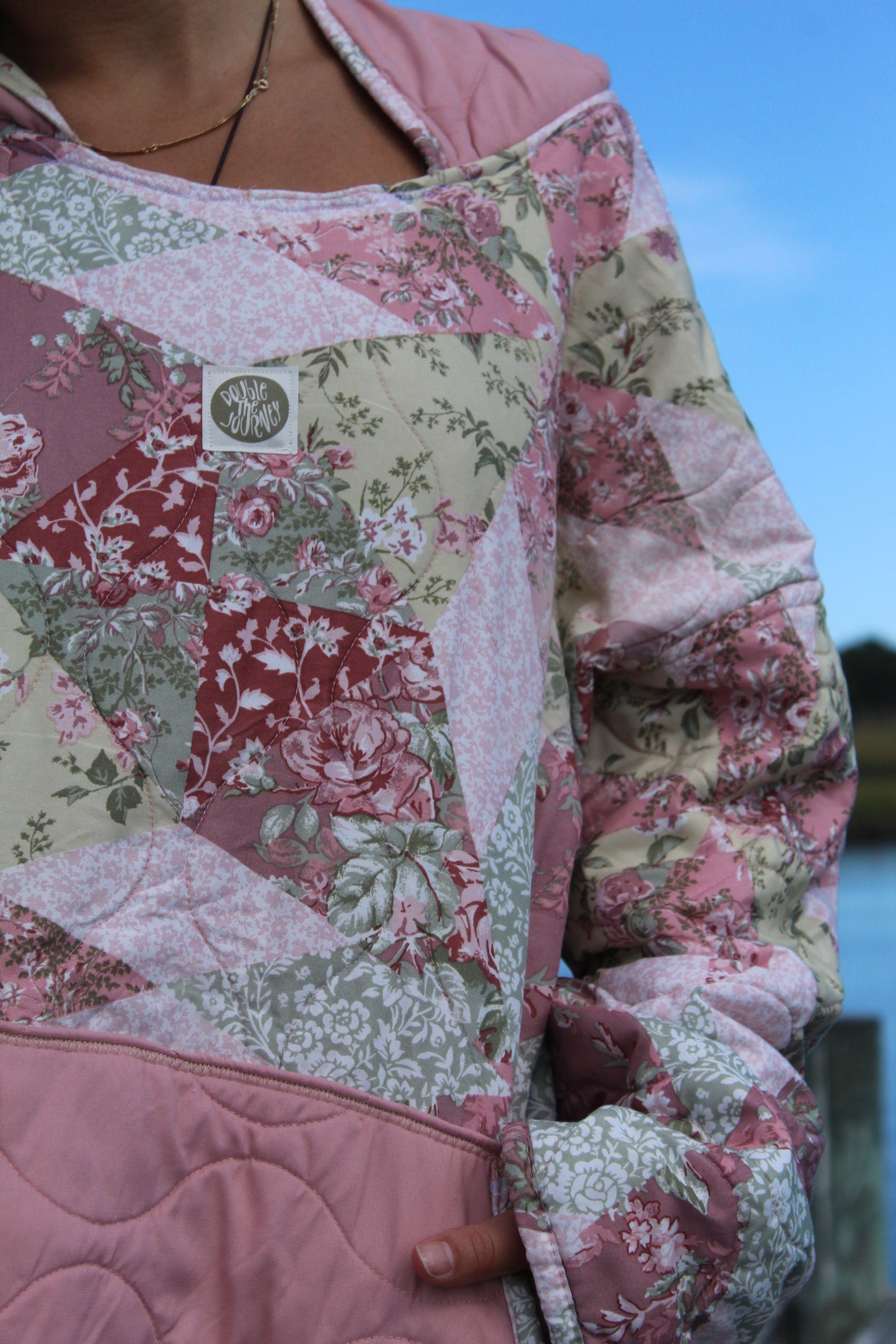 close up of floral pink and green quilted hoodie