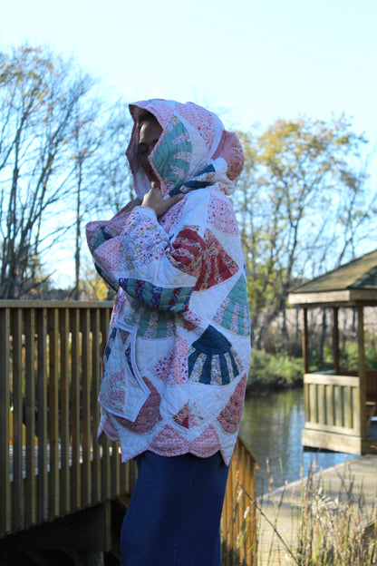Person wearing a colorful quilted hoodie with pink details