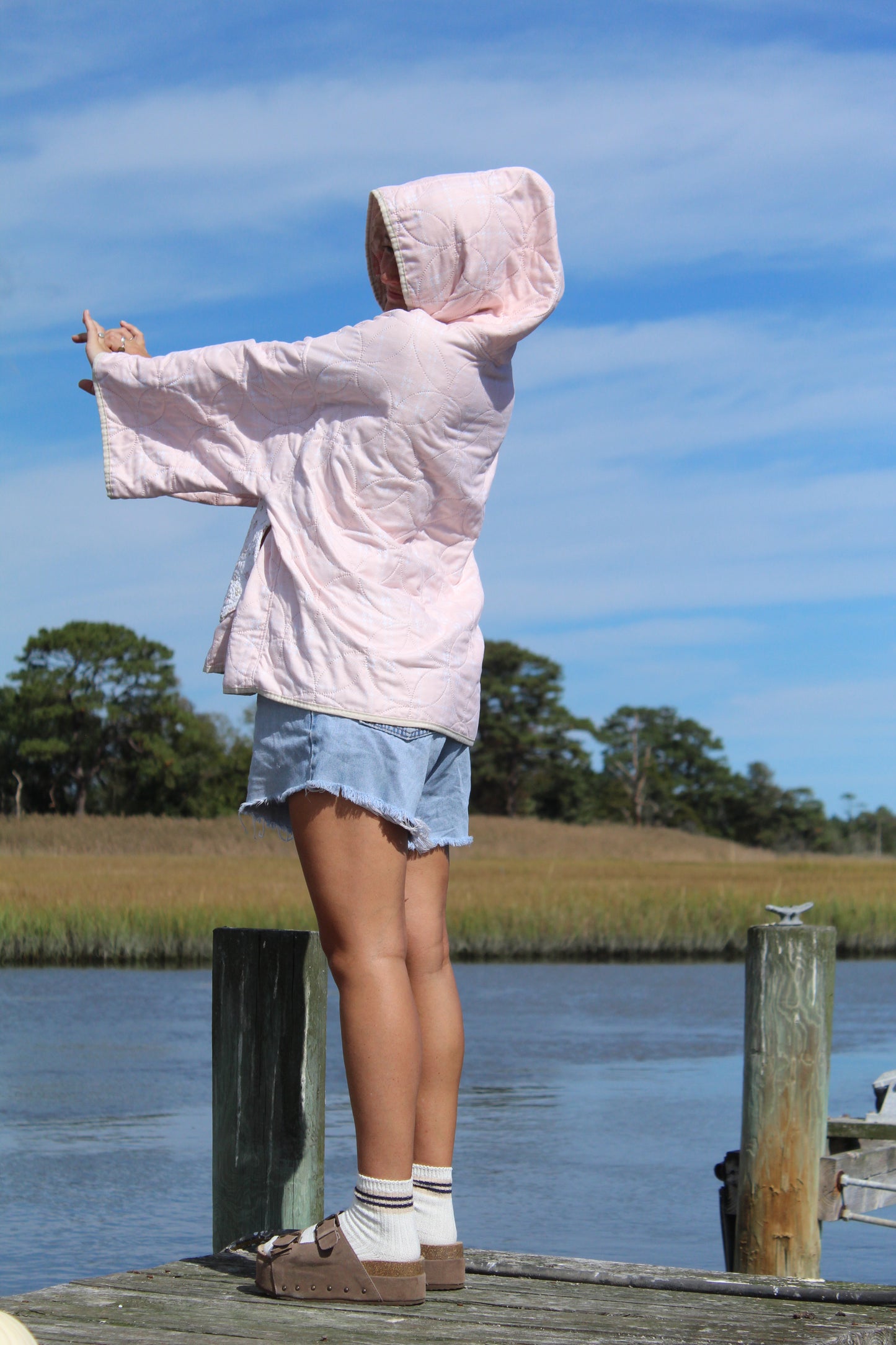 side view of light pink quilted hoodie with plaid pattern