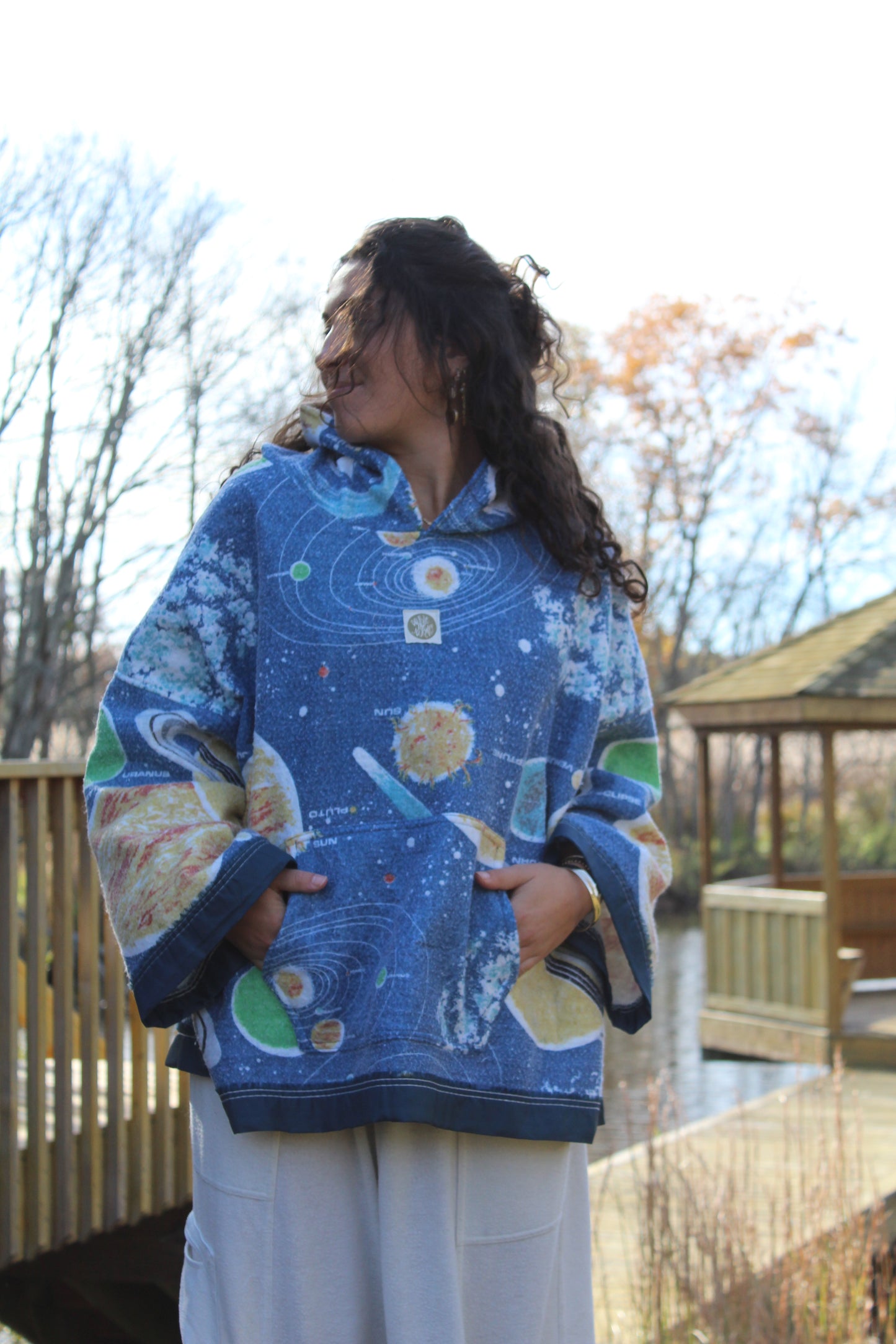 Sustainable hoodie created from repurposed space-themed blanket with starry details