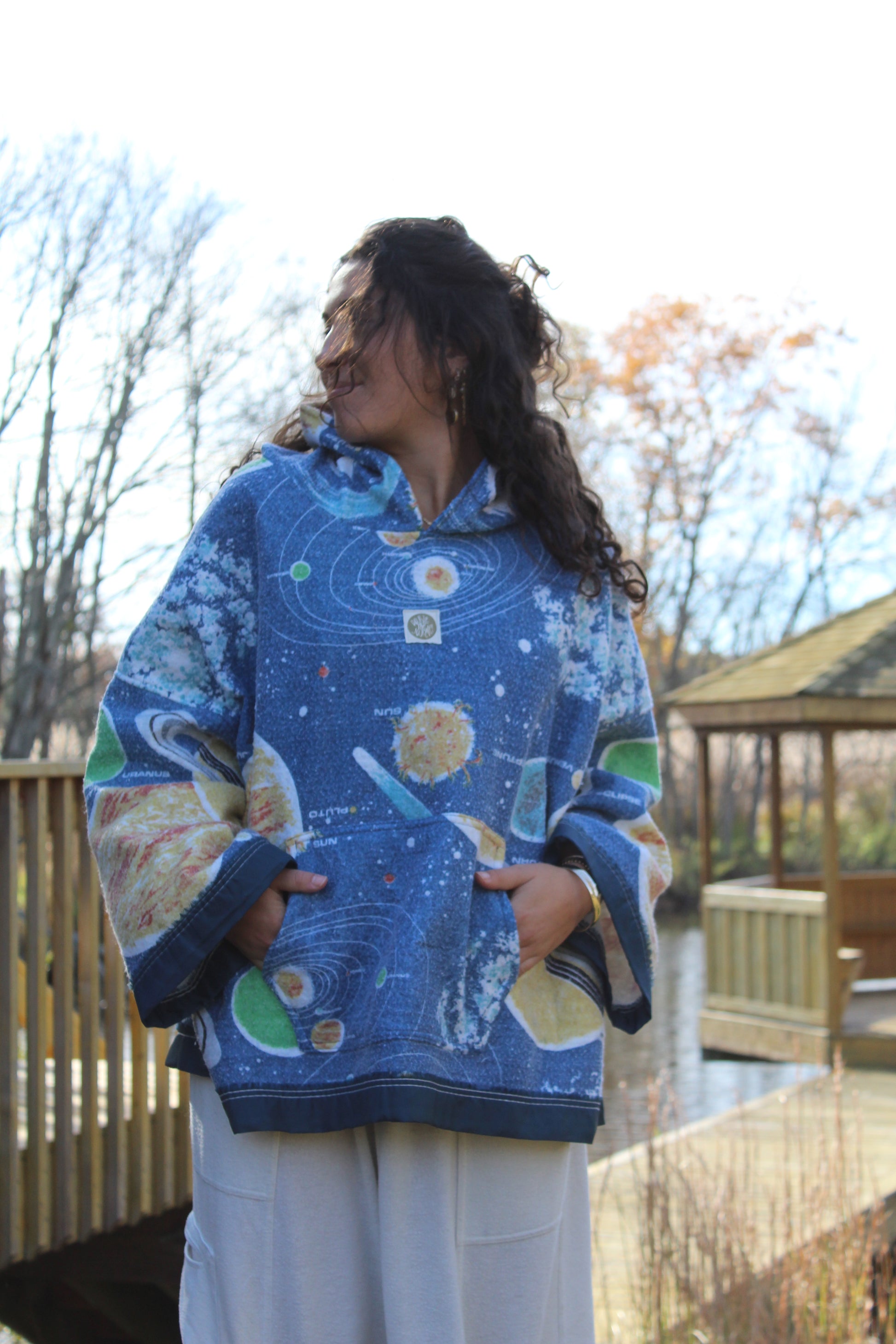 Sustainable hoodie created from repurposed space-themed blanket with starry details