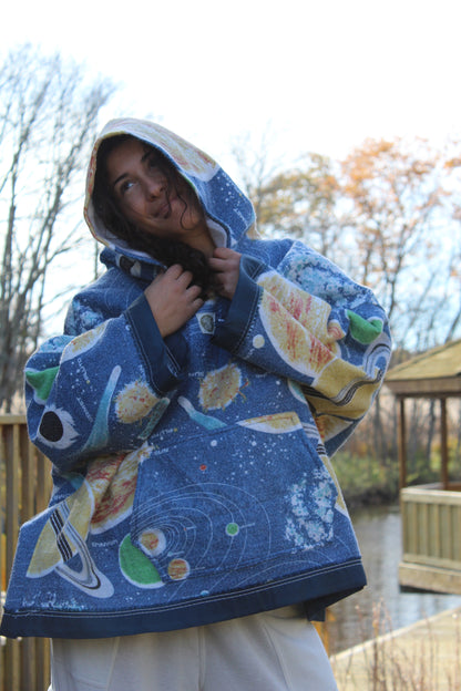 Sustainable hoodie created from repurposed space-themed blanket with starry details