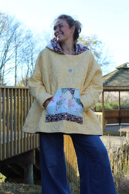 Handcrafted yellow hoodie featuring embroidered flowers and printed pocket details